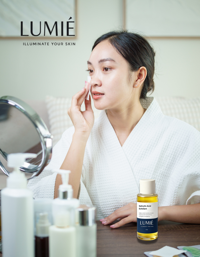 Woman applying skincare product with LUMIE products on a table